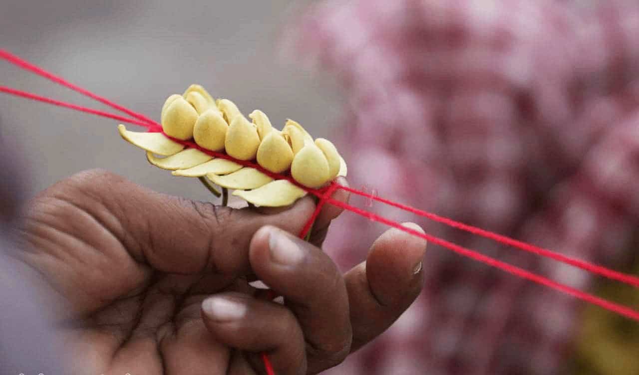 Handmade wheat art with yellow wheat grains and red strings, showcasing cultural craftsmanship.