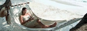Relaxing honeymoon couple on a hammock at the beach in Malaysia, enjoying a peaceful tropical getawa.