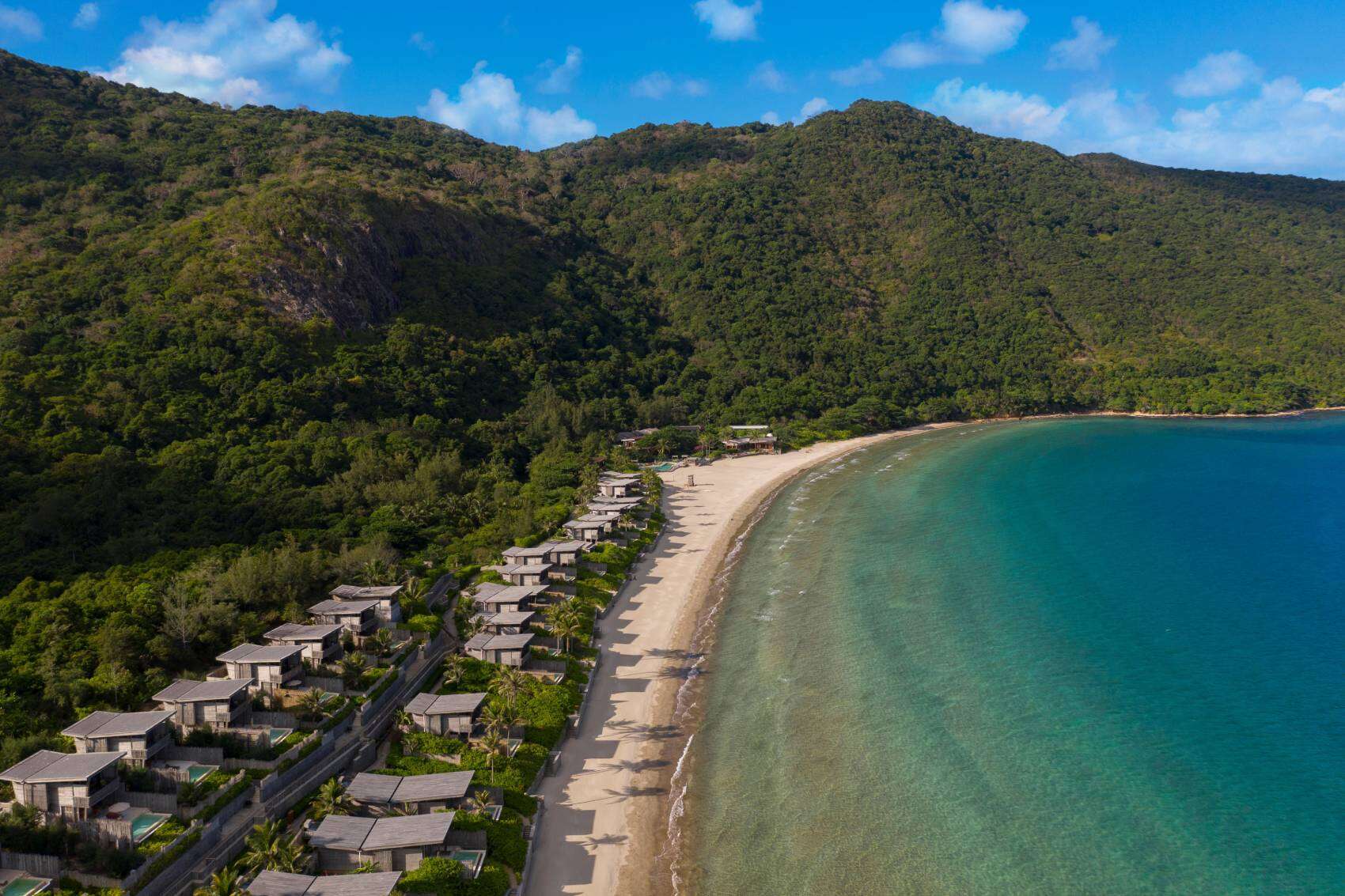 Beachfront villas on a lush green coastline in Vietnam.